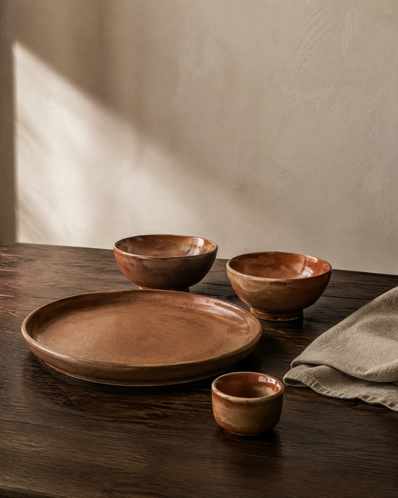 Ceramic homeware and shared-table serving pieces on a linen table